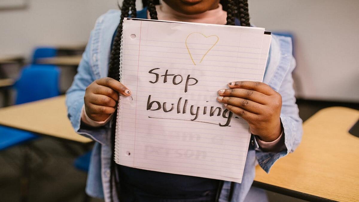 Child holds up paper with a message as part of the Anti-bullying campaign