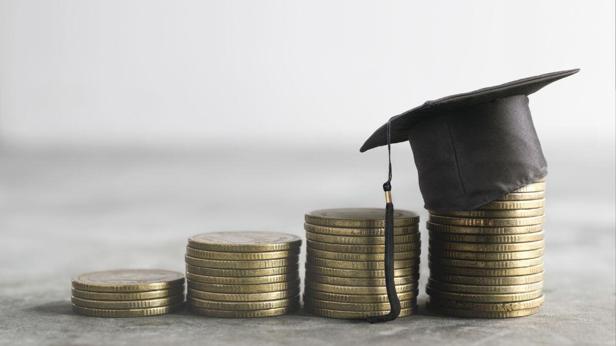 Stacks of coins with a student graduate cap on top