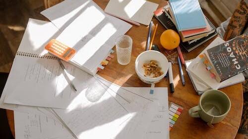 A learner's desk full of matric mathematics practice papers